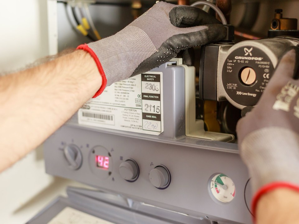 A technician servicing a water heater